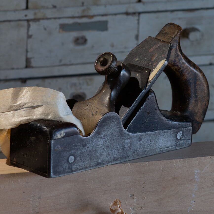 vintage wood plane in traditional woodshop setting